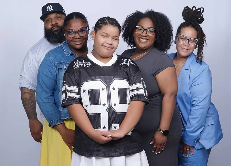 Leslie DeJesus (far right) poses with her family for a portrait.